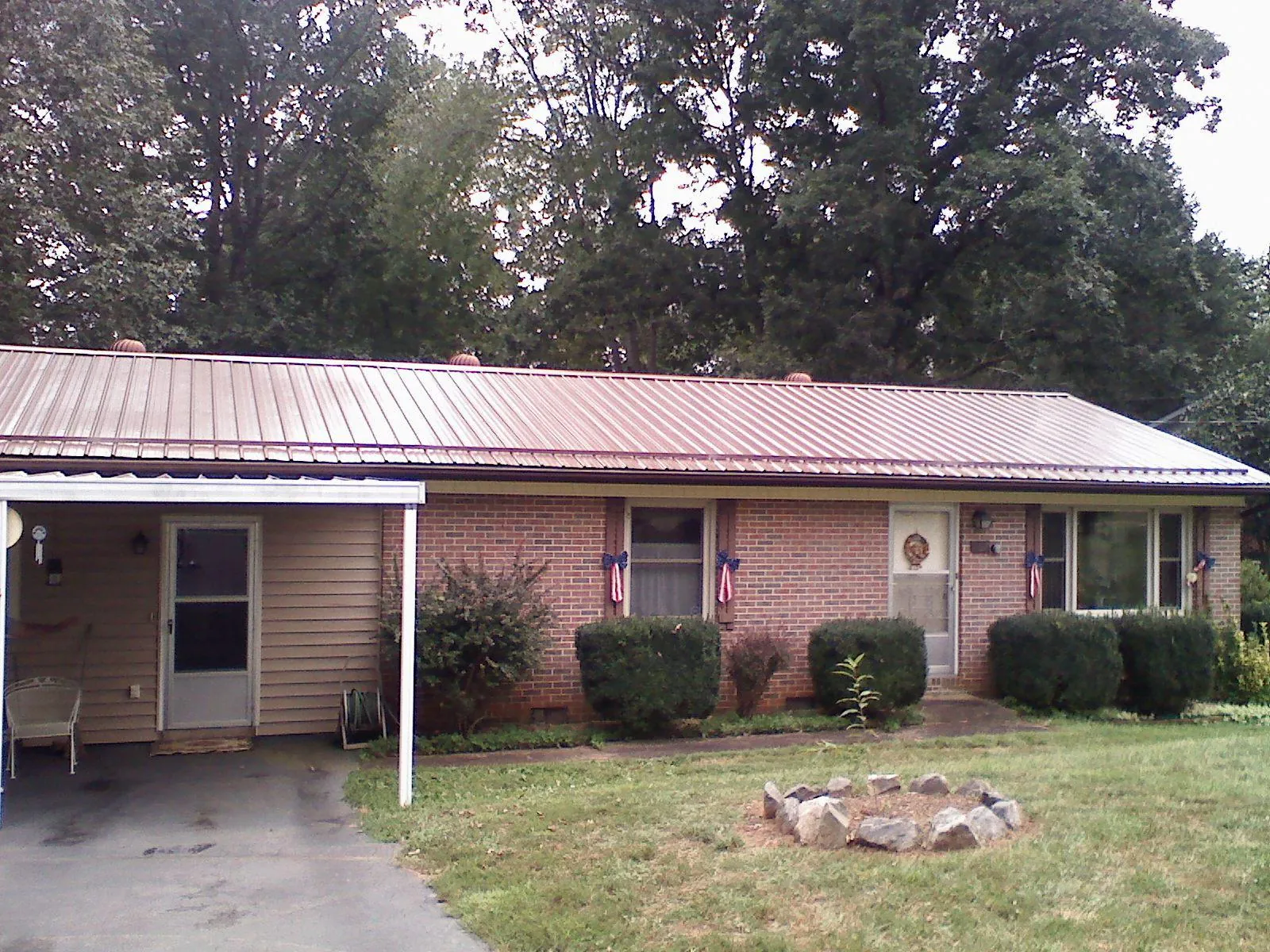 Bronze metal roof and carport on a brick ranch home — Roof Repair work by our crew in Winooski